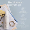 Bali Body Clear 1 Hour Express Tan Flasche auf einem Schreibtisch mit Notizbüchern, Brille, Schmuck und Produktvorteilen auf hellem Hintergrund.