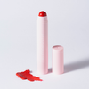 Eine „BLONDESISTER 2 IN 1 – IT’S UP TO YOU LIP OR CHEEK“-Tube steht mit abgenommener Kappe neben einem roten Fleck auf einer weißen Oberfläche.