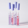 Vier aufrecht stehende Tuben des Produkts „BLONDESISTER 3 IN 1 CUTE LIPPY LIP OIL“ mit violetten Verschlusskappen zeigen im Inneren rosa und violette Farbtöne.