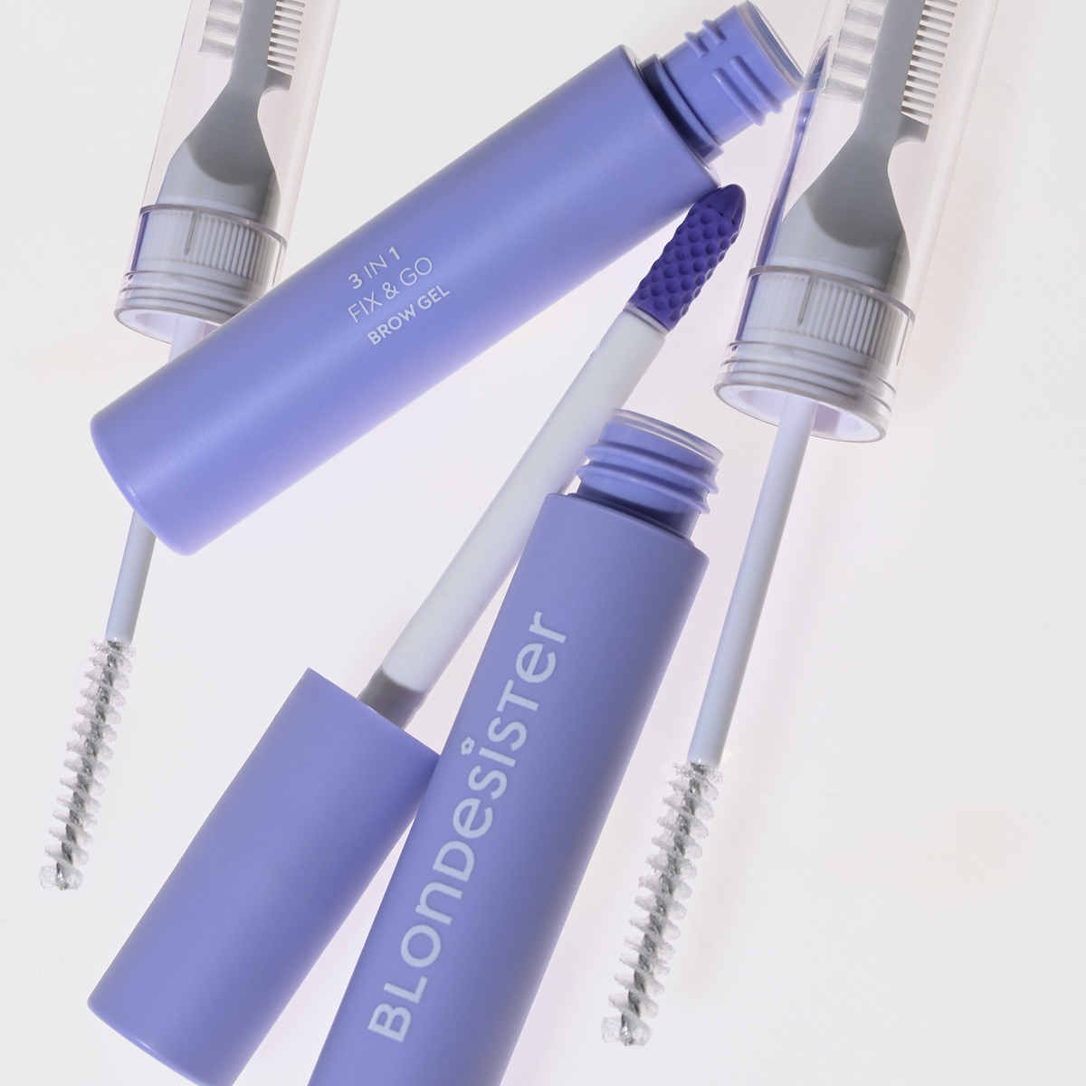 Zwei geöffnete Tuben „BLONDESISTER 3 IN 1 FIX&GO BROW GEL“ mit Applikatoren und zwei verschlossene Pinsel vor weißem Hintergrund.