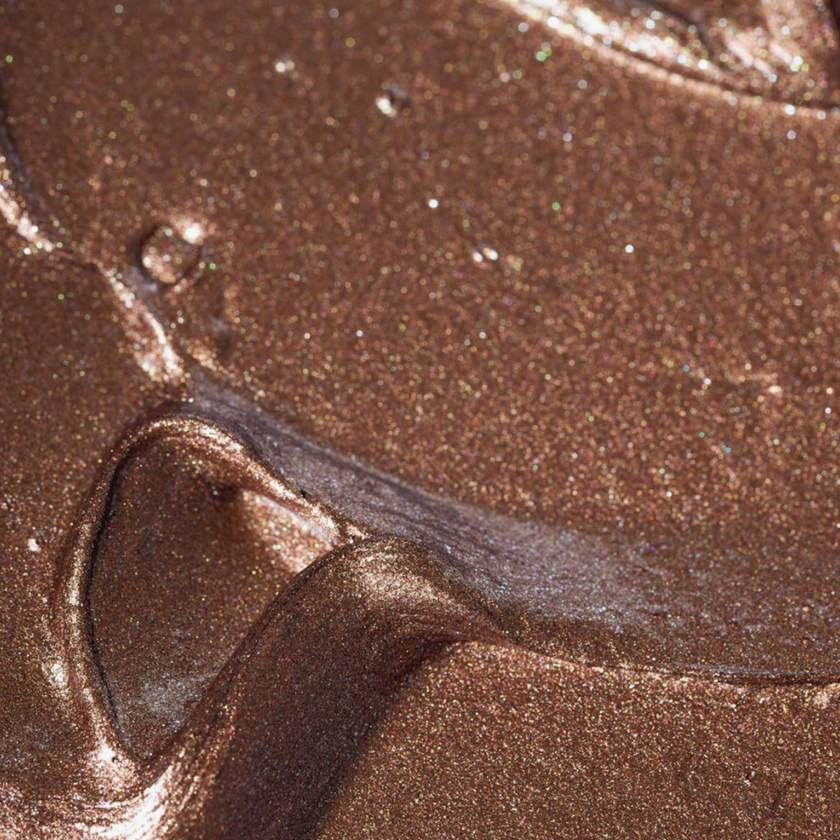 Nahaufnahme des BLONDESISTER GLOWEYE EYESHADOW in metallischem Bronzebraun mit einem geschmeidigen, schimmernden, strukturierten Finish.