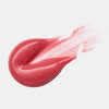 Ein rosafarbener, glänzender Tupfer des Diamond Glaze Gloss Stick von Catrice Cosmetics bringt einen weißen Hintergrund zum Strahlen.