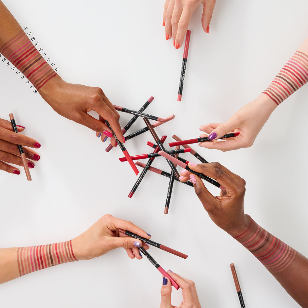 Sechs Hände mit unterschiedlichen Hauttönen halten und greifen nach dem Essence 8h matte comfort lipliner auf einer weißen Fläche, auf der Farbmuster zu sehen sind.