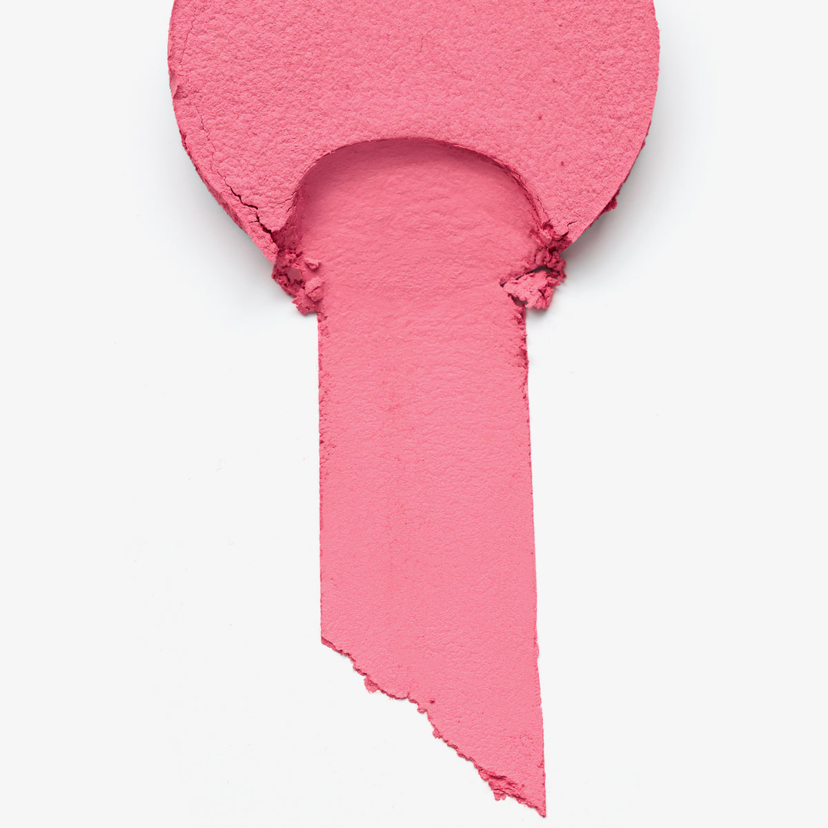 Ein Muster von Essence soft TOUCH BOUNCY BLUSH in leuchtendem Pink, mit einer abgerundeten Spitze und einem verschmierten Streifen.