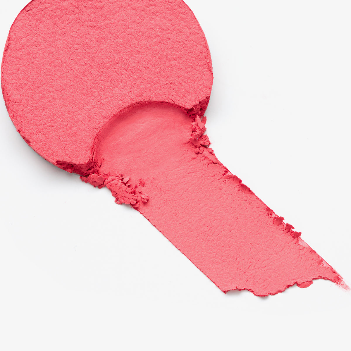 Korallenfarbener Blush, teilweise abgetragen, mit samtig-weicher Textur auf weißem Hintergrund.