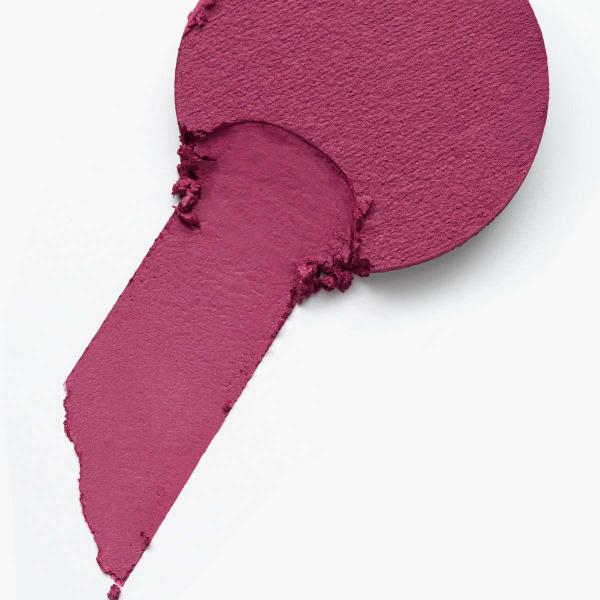 Beeriger Blush, teils abgetragen, mit weicher Textur und matter Oberfläche auf weißem Hintergrund.