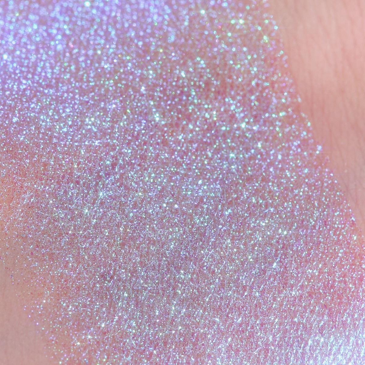 Ein schimmernder, schillernder blauer Glitzerstreifen des Opal Multichrome Loose Eyeshadow Dreamer auf einem Arm.