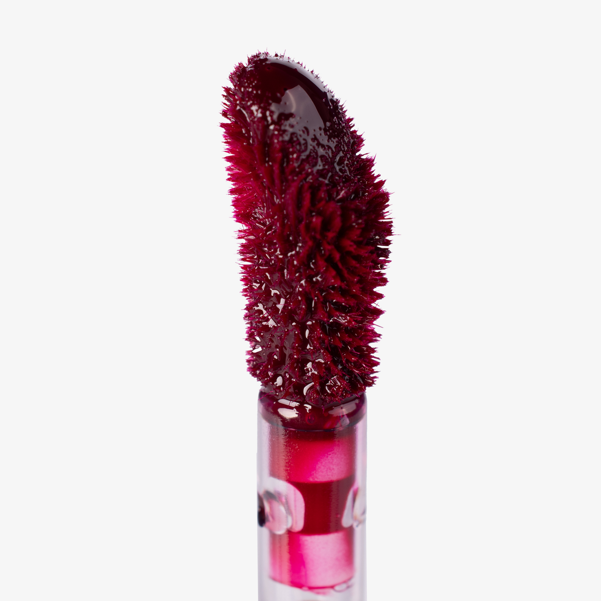 Nahaufnahme eines Applikators von Lethal Cosmetics Infinity Lip Stains, dessen weiche, strukturierte Spitze mit dunkelrotem Produkt beschichtet ist, vor einem weißen Hintergrund.