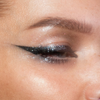 Nahaufnahme eines Auges mit glitzerndem Eyeliner und Augenlid. Look kreiert mit dem Sparkl Flash.