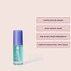 Transparente Flasche True Soft Argan Oil mit lila Deckel aus der Pure Volume Beauty Bag 2025, neben Produktvorteilen auf blassrosa Hintergrund.