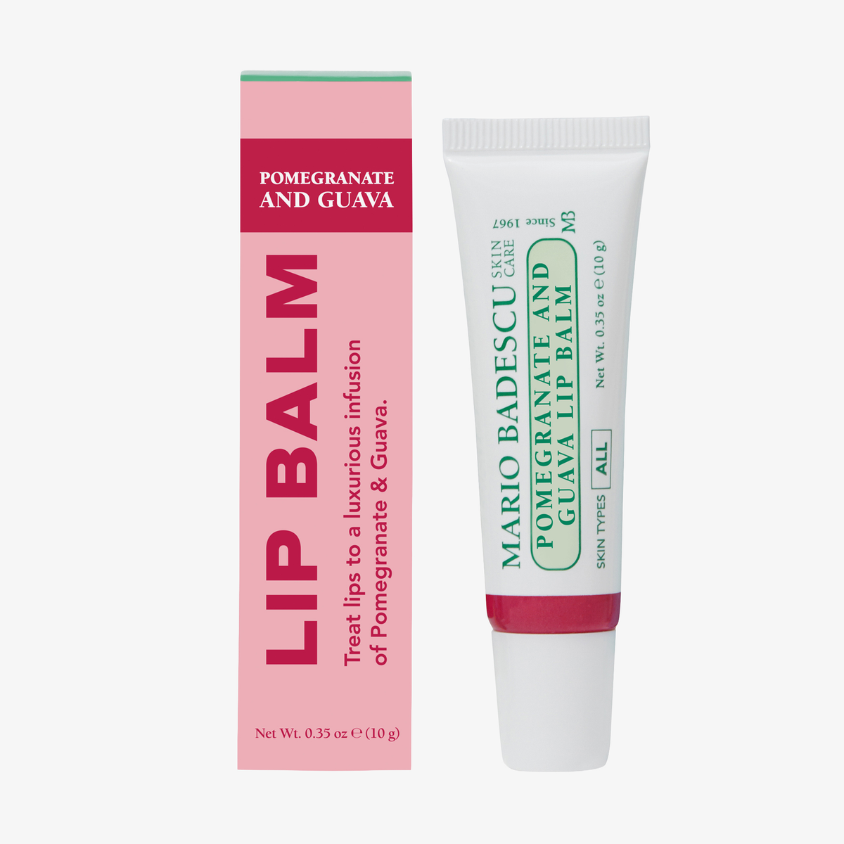 Mario Badescu Watermelon and Basil Lip Balm Tube neben seiner rosa-roten Schachtel auf weißem Hintergrund.