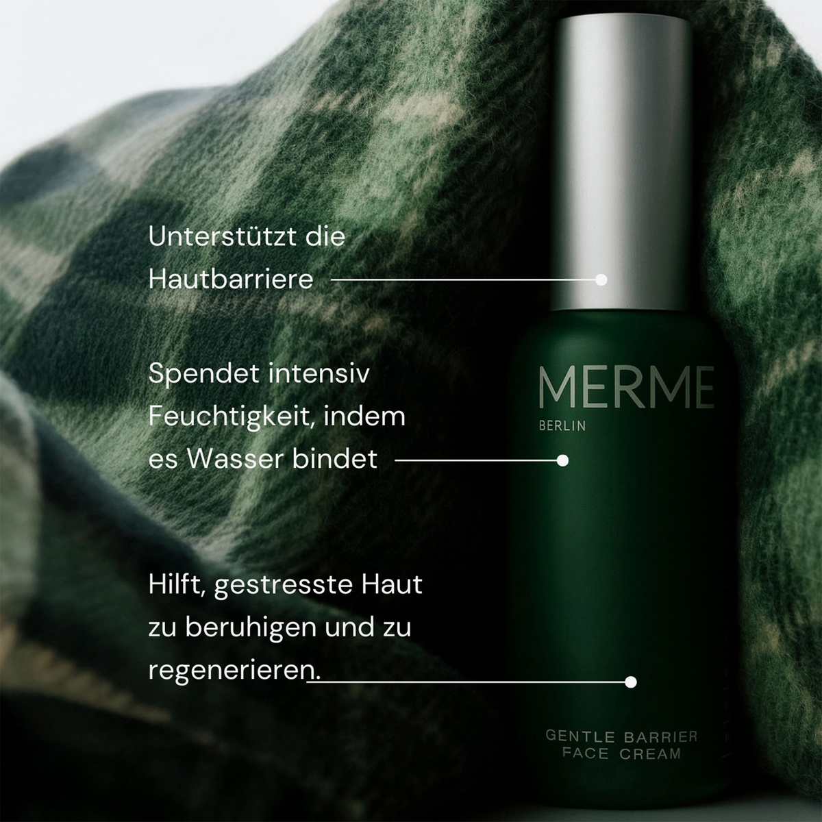 Eine grüne MERME Gentle Barrier Face Cream Flasche auf kariertem Stoff, mit deutschem Text, der die Vorteile der Hautpflege hervorhebt.