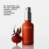 Die MERME Glowing Guard Face Oil Flasche mit Pumpe steht neben einer Hagebuttenfrucht, auf der ein deutscher Text die Vorteile für die Haut hervorhebt.