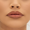 Nahaufnahme der Nase und der Lippen einer Frau mit glatter Haut, die den Mesauda Milano Hydramorphosis Glossy Nude Lipstick trägt.