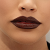 Nahaufnahme der Lippen einer Frau, die Mesauda Milano Hydramorphosis glänzenden dunkelbraunen Lippenstift auf makelloser Haut trägt.