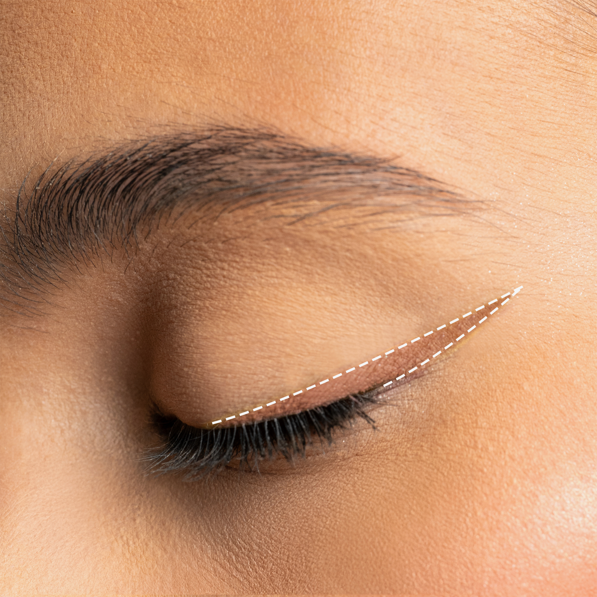 Augen-Make-up mit helllbraunen Winged Eyeliner in tiefem Schwarz, präzise aufgetragen und mit feiner weißer Linie akzentuiert.