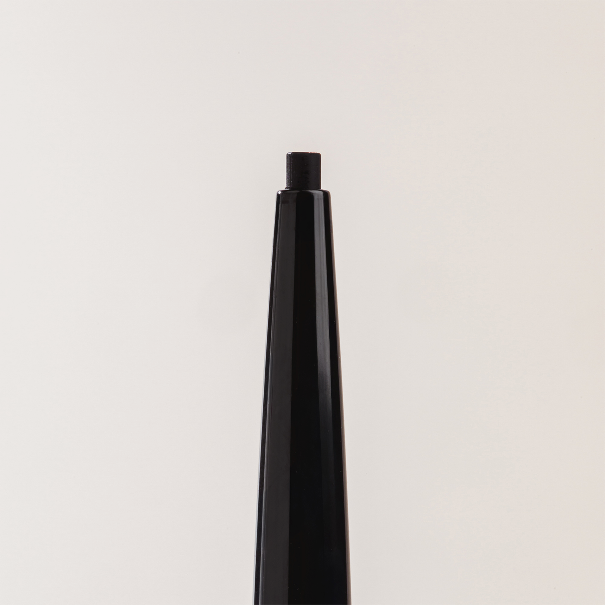 Nahaufnahme des NABLA Cosmetics Cupid's Arrow Micro Make-up Stift mit freiliegender Spitze vor einem weißen Hintergrund.