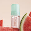 NABLA Cosmetics Lip Candy Oil Watermelon, umgeben von Wassermelonenscheiben vor hellem Hintergrund.