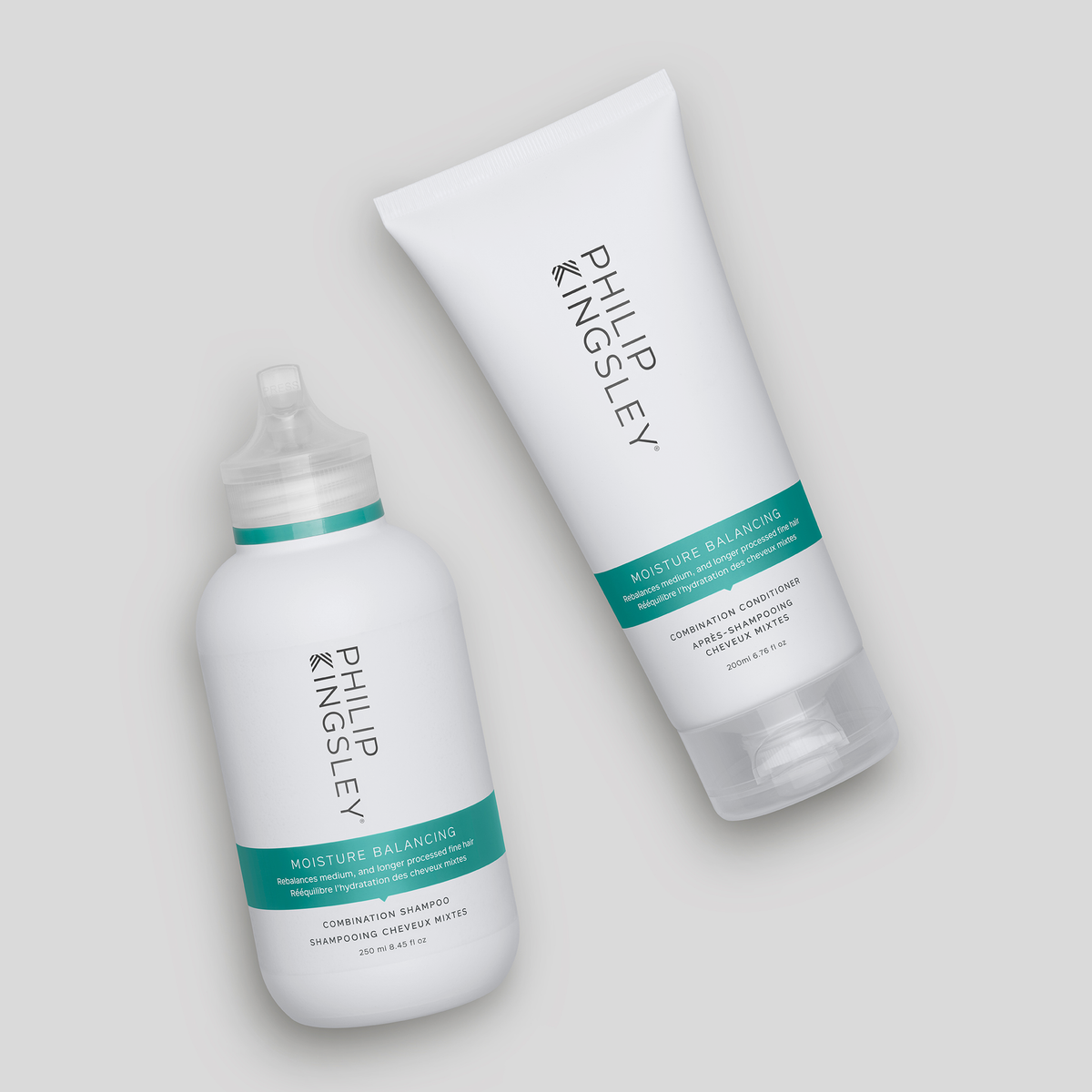 Zwei „Philip Kingsley Moisture Balancing Shampoos“ in weißen Flaschen mit türkisfarbenen Etiketten auf hellgrauem Hintergrund.