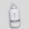 Auf einem hellgrauen Hintergrund ist eine weiße Flasche des Shampoos „No Scent No Colour“ von Philip Kingsley zu sehen.