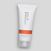 Eine weiße Tube „Philip Kingsley Re-Moisturizing Conditioner“ mit einem orangefarbenen Etikett auf grauem Hintergrund.