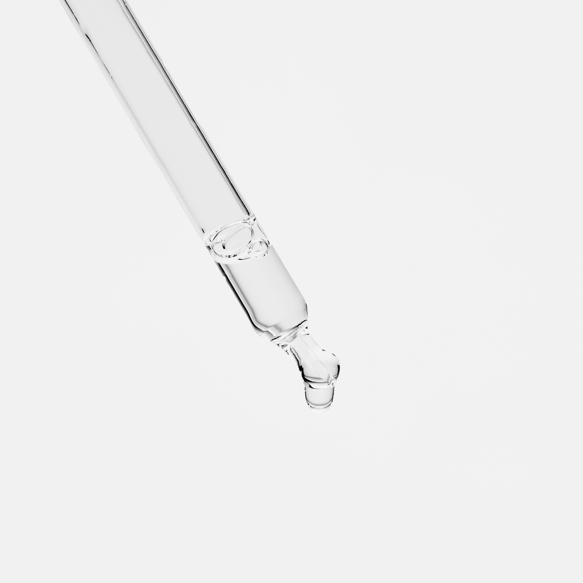 Ein klarer Glastropfer gibt einen einzelnen Tropfen Bio-Pilixin® Serum von Scandinavian Biolabs vor einem schlichten weißen Hintergrund ab.