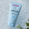 Vor einem wässrigen Hintergrund ist eine Tube der „Skinlick Peptide Gloss Bond Repair Mask“ mit Wassertropfen zu sehen.