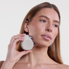 Eine Frau verwendet das STYLPRO Dual Microcurrent Face & Body Toning Device auf ihrer Kieferlinie vor einem schlichten weißen Hintergrund.