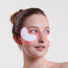 Eine Frau trägt vor einem schlichten Hintergrund leuchtend rote STYLPRO LED Patch Duo unter den Augen.