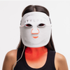 Eine Frau trägt die STYLPRO Wavelength Pro 5 in 1 LED-Maske, die ein rotes Licht unter ihrem Hals und ihrer Brust ausstrahlt.
