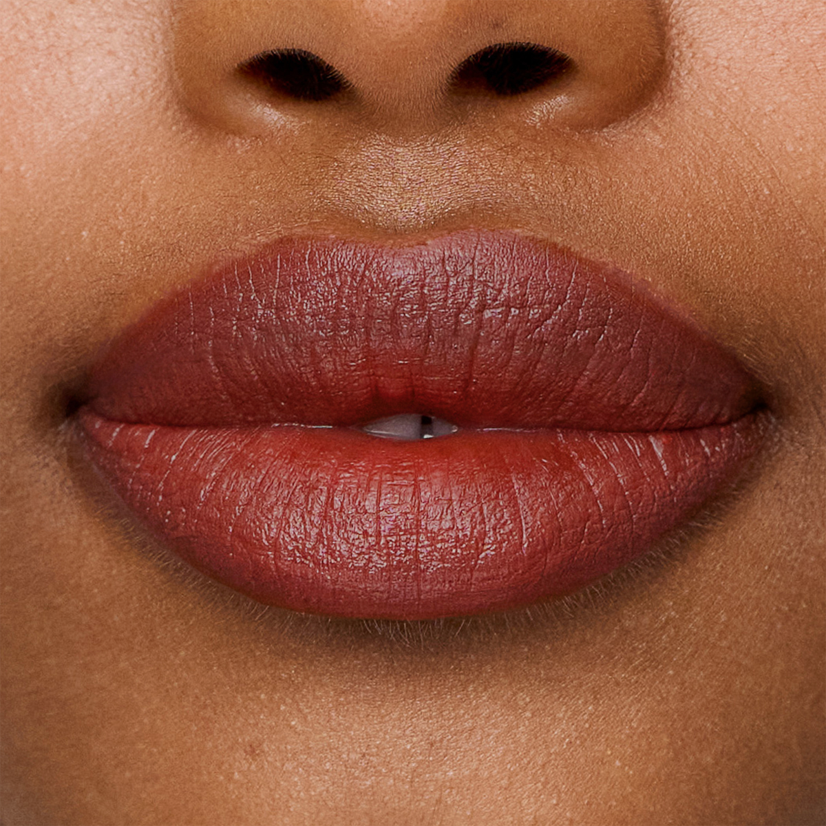 Nahaufnahme der Lippen mit dem Lippenstift „SWEED Le Lipstick“ in tiefem Rot, wobei die natürliche Hautstruktur und ein Teil der Nase hervorgehoben werden.