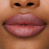 Nahaufnahme von glatter, brauner Haut und natürlichem Make-up, mit dem Lippenstift „SWEED Le“ auf den Lippen.