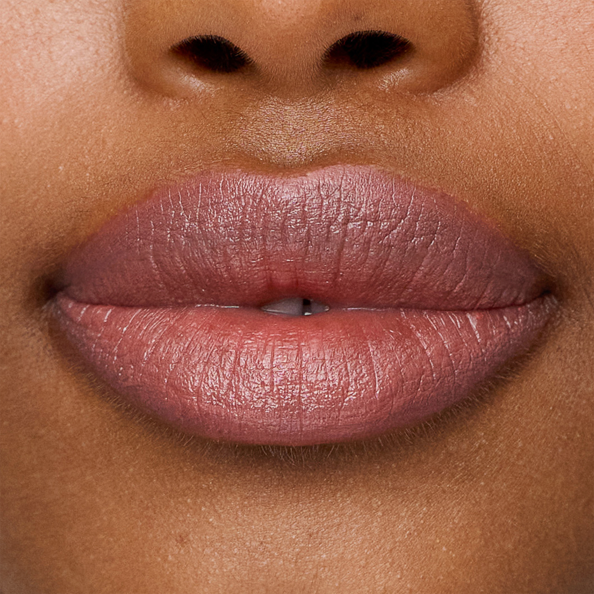 Nahaufnahme der Lippen, geschminkt mit dem Lippenstift „Le Lipstick“ von SWEED in einem natürlichen Rosabraun, die eine glatte Haut und einen Hauch der Nase darüber zeigen.
