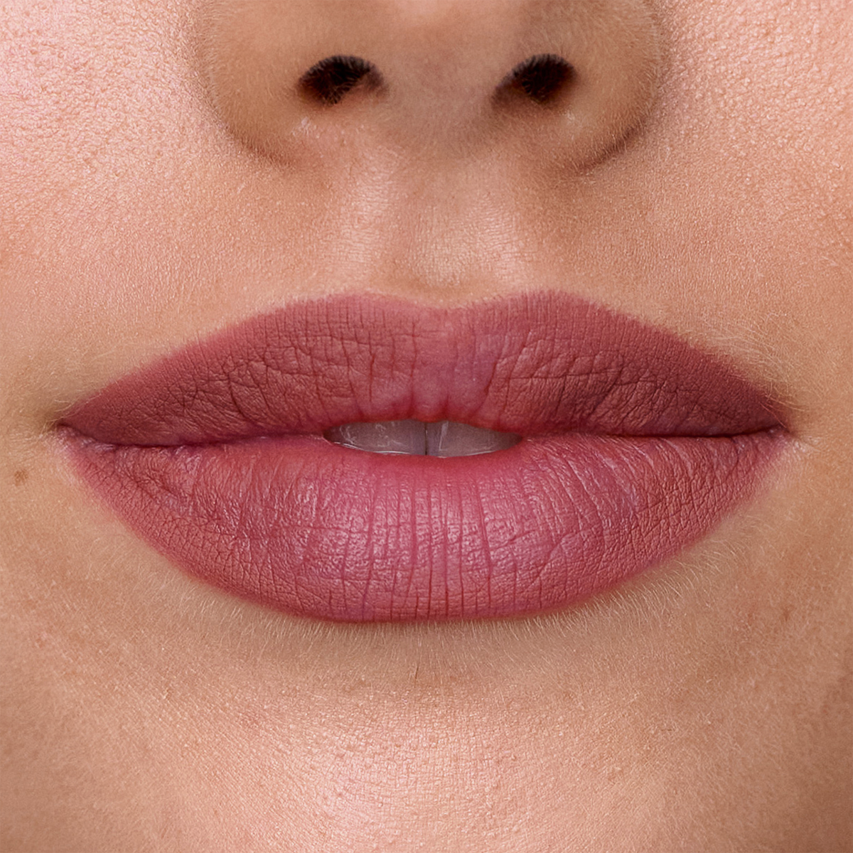Nahaufnahme der Lippen mit dem SWEED Lip Liner in mattem Rosa, die glatte Haut und einen Blick auf die Zähne durch die leicht geöffneten Lippen zeigt.