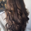 Von hinten gesehen: langes, welliges braunes Haar mit sanften Locken und Strähnchen, gestylt mit „The Hair Serum“ von SWEED.