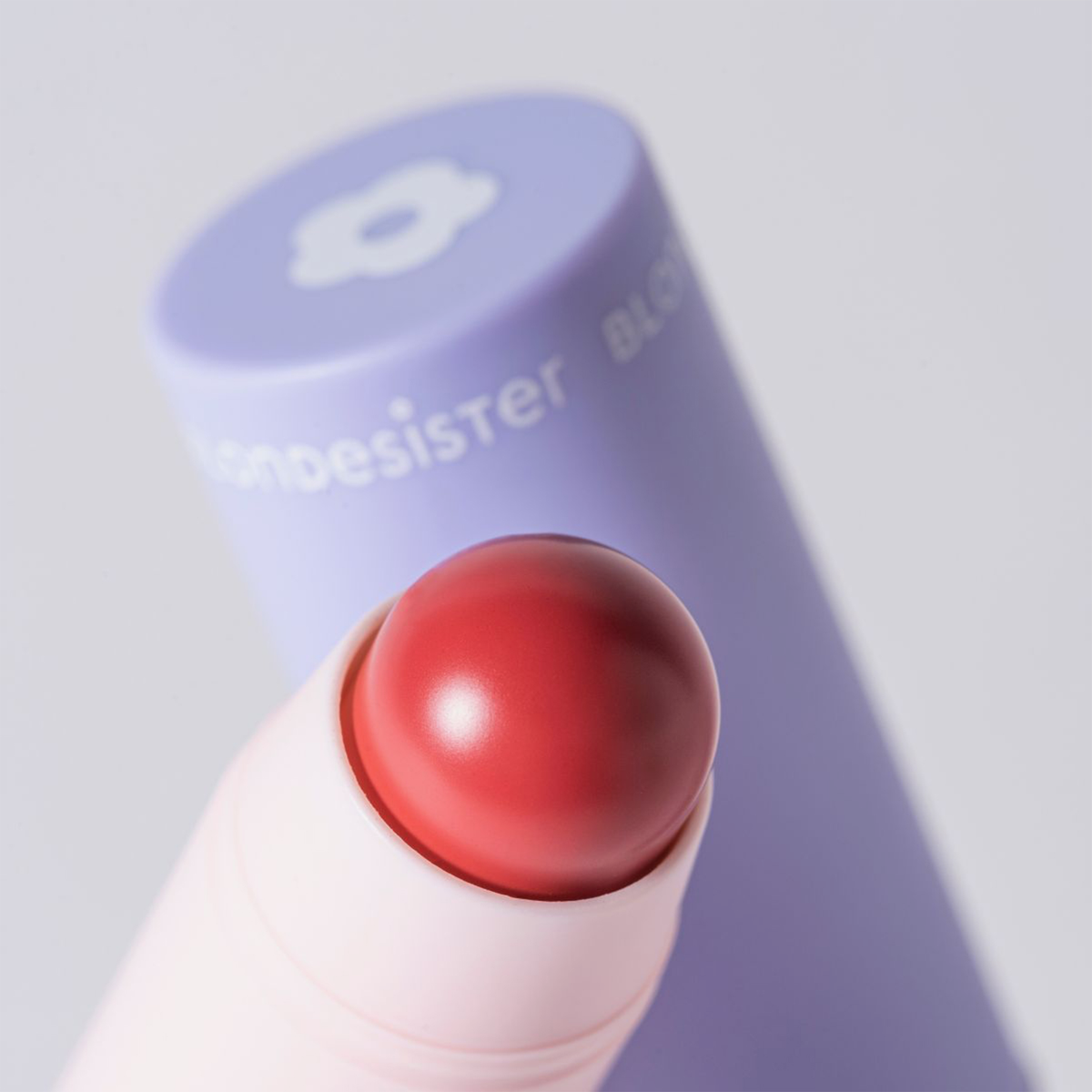 Eine Nahaufnahme von BLONDESISTER 2 IN 1 IT’S UP TO YOU „Lip or Cheek“ in Rot mit violetter Kappe auf einem hellen Untergrund.