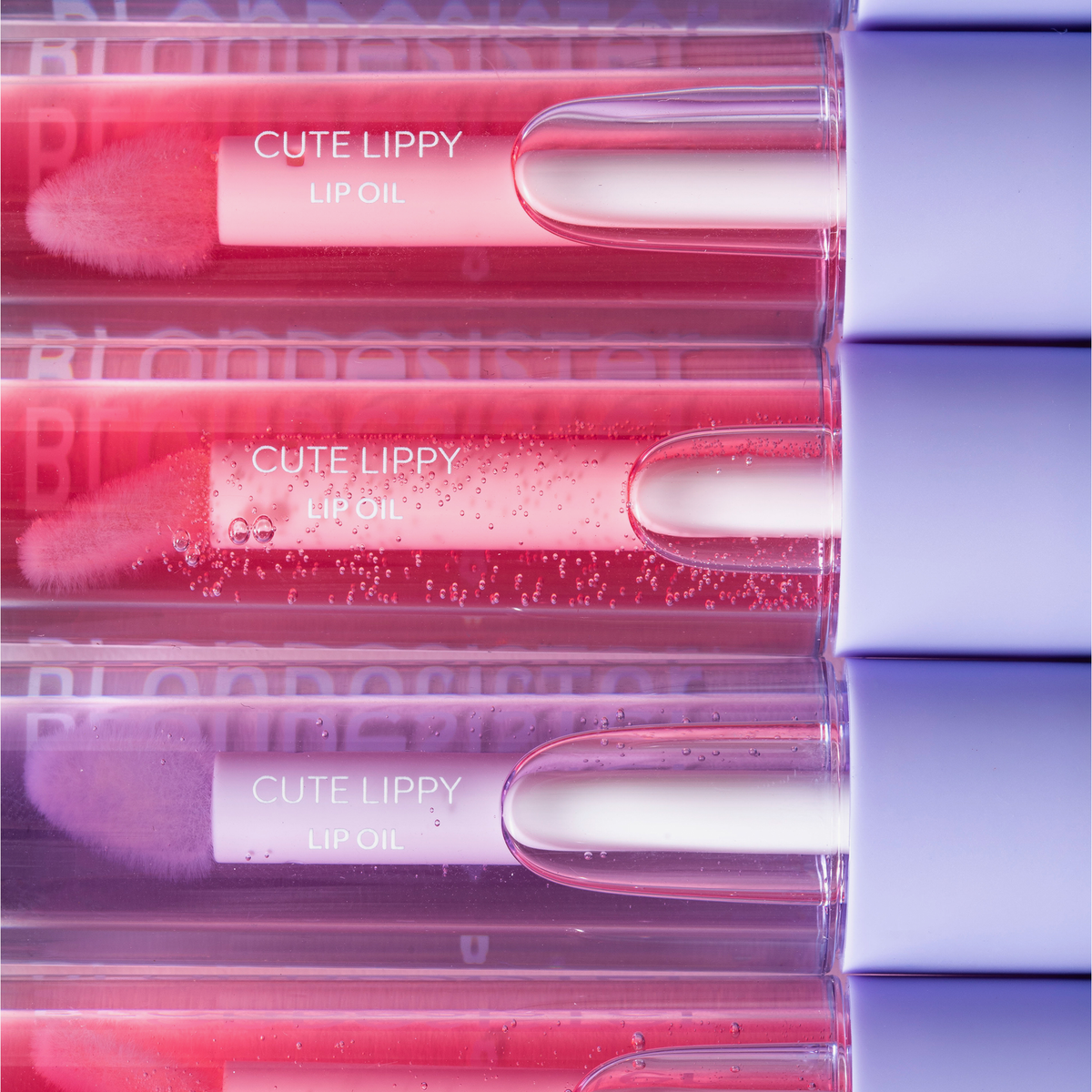 BLONDESISTER 3-in-1 „CUTE LIPPY“ Lippenöl-Set: Rosé-, Korallen- und Lila-Töne mit weichem Applikator und transparenter Verpackung.