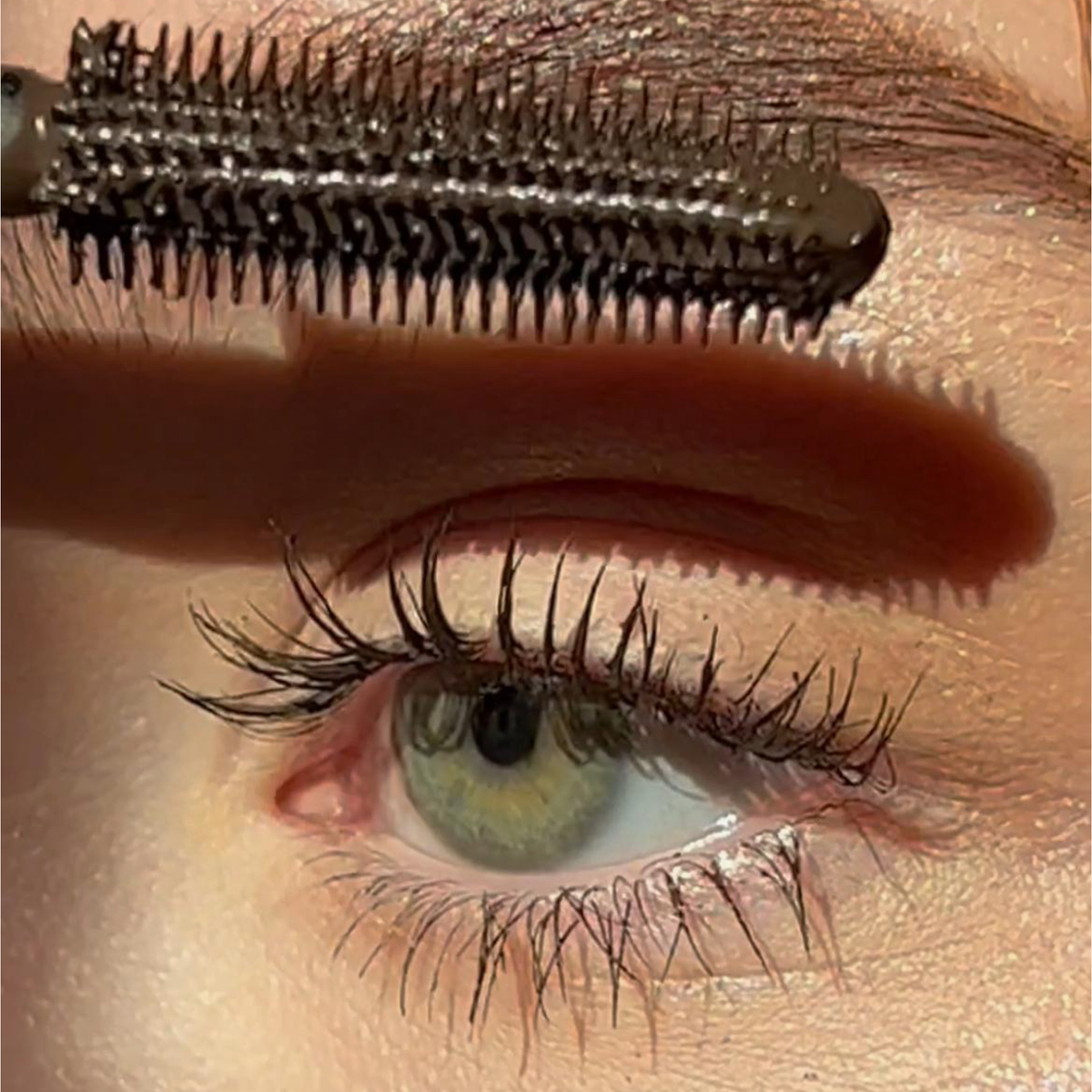 Nahaufnahme eines grünen Auges beim Auftragen der BLONDESISTER 4 IN 1 CLICK & TURN MASCARA, die die Wimpern detailreich hervorhebt und für ein makelloses Make-up sorgt.