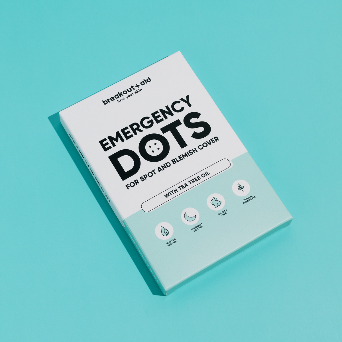 Eine Packung Breakout+Aid Emergency Dots mit Teebaumöl, versehen mit Symbolen für Teebaumöl, Anwendung über Nacht, tierversuchsfrei und natürliche Inhaltsstoffe.