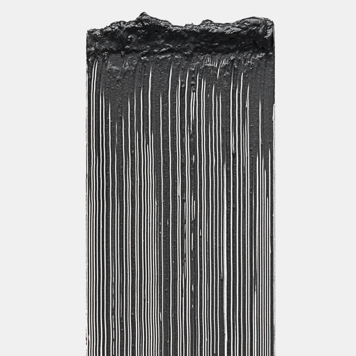 Schwarze Mascara in gleichmäßigen, vertikalen Streifen aufgetragen, mit sichtbarer Textur und cremiger Konsistenz vor weißem Hintergrund.