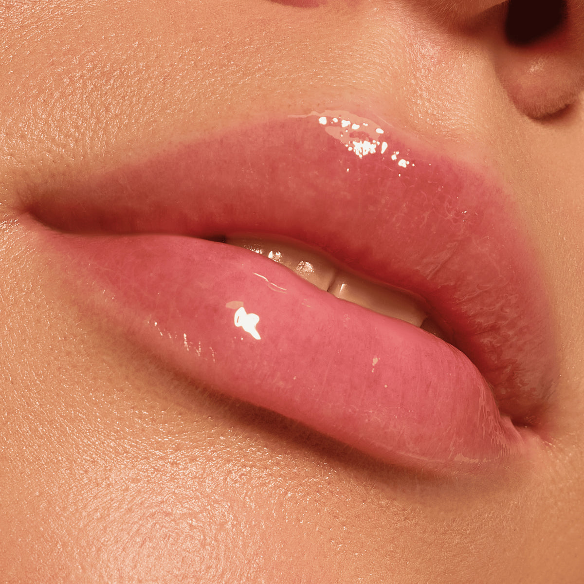 Nahaufnahme glänzender, rosafarbener Lippen mit natürlichem Glanz und glatter Haut, erzielt mit der Catrice Cosmetics Pillow Plush Peptide Lip Mask 010.