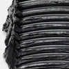 Nahaufnahme von aufgetragenem schwarzem Mascara-Produkt in mehreren dicken, glänzenden Schichten mit sichtbarer Textur.