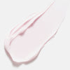 Ein Abstrich der zartrosa Creme von Color Wow Dreaming Treatment auf weißem Hintergrund.