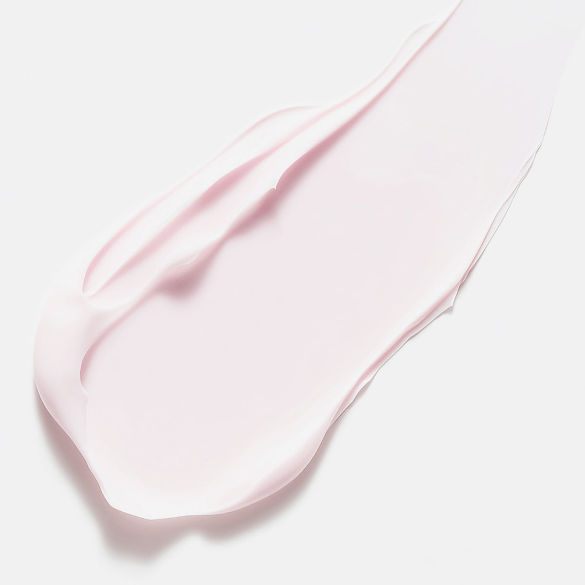 Ein Abstrich der zartrosa Creme von Color Wow Dreaming Treatment auf weißem Hintergrund.