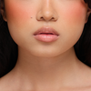 Nahaufnahme des unteren Gesichts einer Frau mit glatter Haut und natürlichem Make-up, die Dominique Cosmetics Juicy Lip Balm in einem neutralen Farbton trägt.