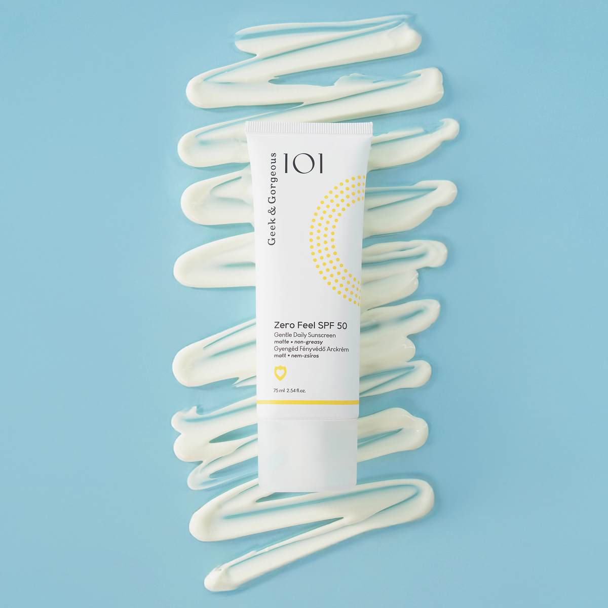 Eine weiße Tube Geek & Gorgeous Zero Feel SPF 50 auf blauem Hintergrund mit verschnörkelter Sonnenschutzcreme dahinter.