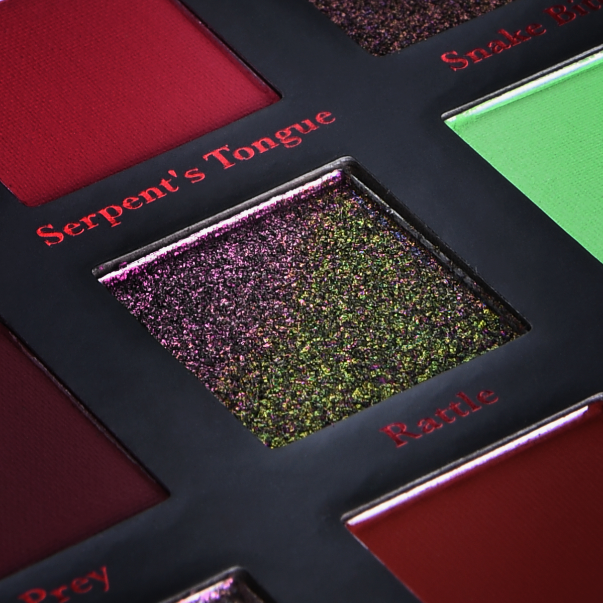 Eine Nahaufnahme der Serpentine Palette von Lethal Cosmetics mit dem glitzernden Farbton Rattle und matten roten und grünen Lidschatten.
