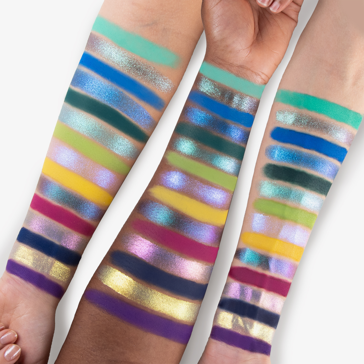 Drei Unterarme unterschiedlicher Hautfarben zeigen leuchtende, schimmernde Lidschattenswatches aus der SpongeBob Movie Palette von Lethal Cosmetics in einer Reihe von kräftigen Farbtönen und Finishes.