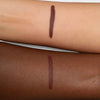 Zwei Unterarme mit je einem dunkelbraunen Lippenstift-Swatch, um die Farbwiedergabe auf heller und dunkler Haut zu zeigen.