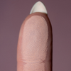 Eine Nahaufnahme einer Fingerkuppe mit detaillierten Fingerabdruckrillen, die The Single von LH Cosmetics auf einem unscharfen lila Hintergrund zeigt.
